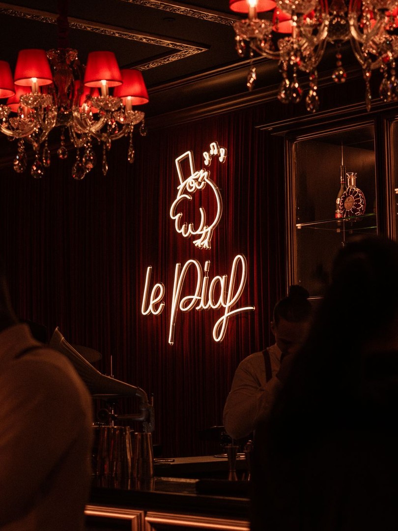 The Le Piaf neon and the piano at Le Piaf Dubaï